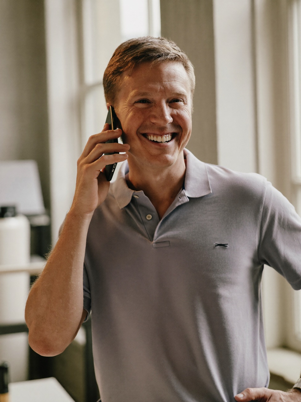 Lokaler Unternehmer geht entspannt lächelnd ans Telefon